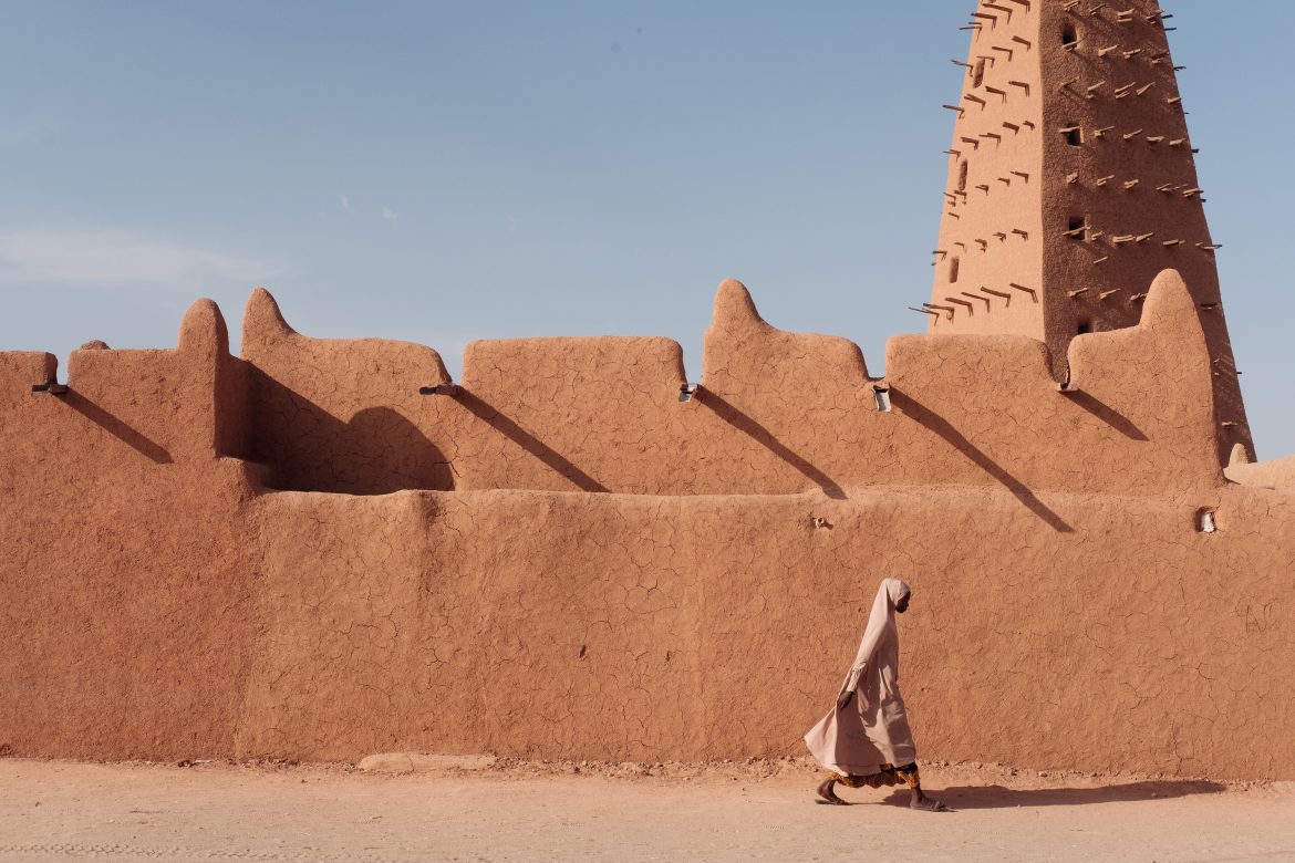 Una donna passa davanti alla moschea di Agadez, la struttura in mattoni di fango più alta del mondo. - Foto di Guy Peterson/Panos La storica città tuareg nel cuore del Niger, un tempo fulcro del commercio carovaniero e poi meta turistica, è oggi crocevia di migranti e di cercatori d’oro. Alle prese con boom demografico, insicurezza e cambiamenti climatici, combatte per preservare la sua identità e il suo ruolo strategico nel Sahel. Leggi l'intero servizio nel numero di gennaio-febbraio della rivista Africa.