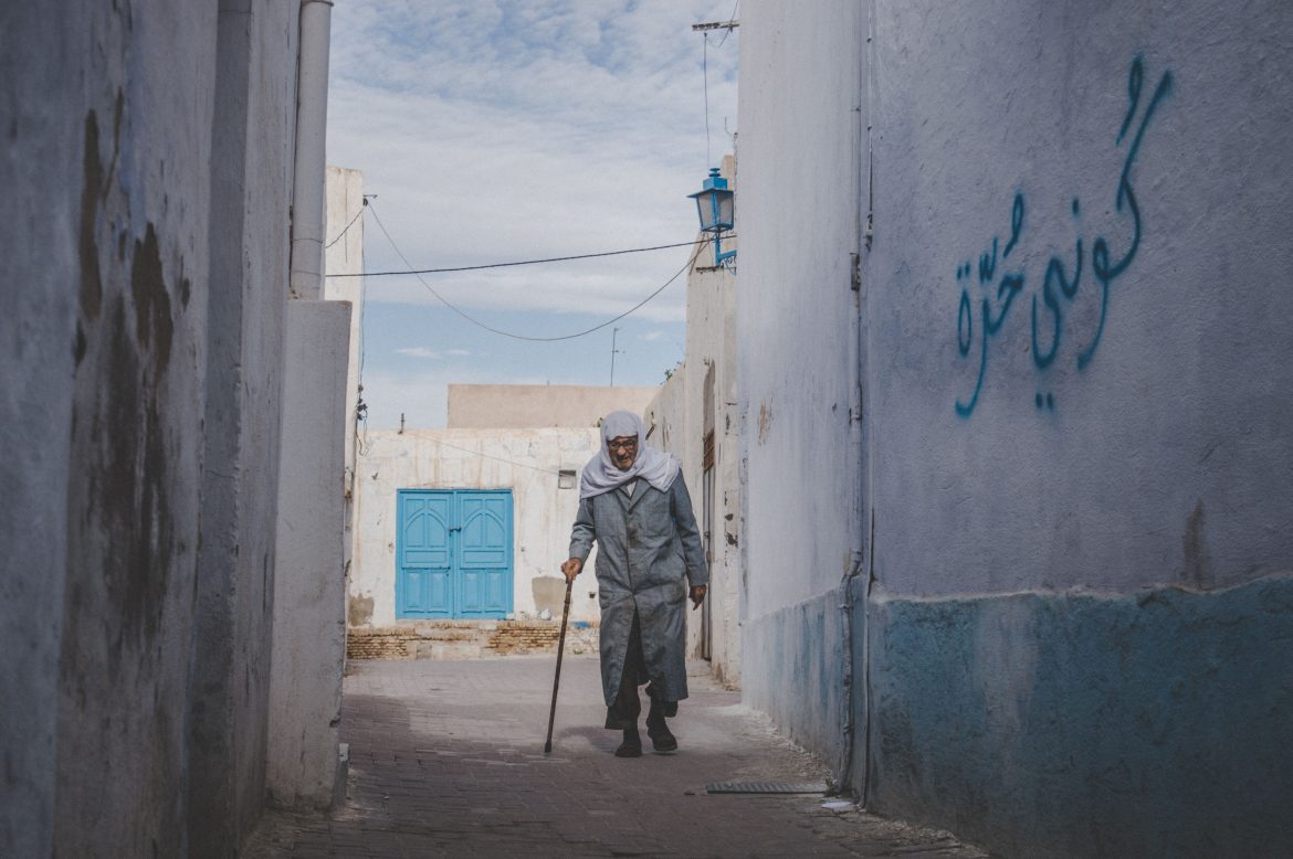 Un uomo anziano cammina in un vicolo in Tunisia