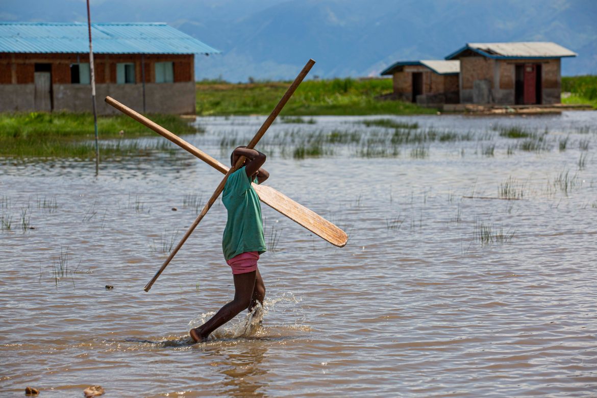 Un bambini cammina nel mezzo di un'alluvione